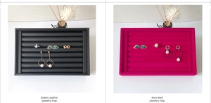Detail view of black leather and rose red velvet jewelry trays for rings and earrings