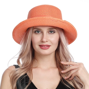 Close-up of vibrant orange woven straw hat featuring detailed texture and rolled edge