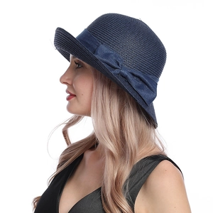 Elegant navy blue straw sun hat for women featuring a large decorative bow on a plain white background