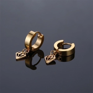 Polished gold rhombus drop earrings in stainless steel on a reflective surface