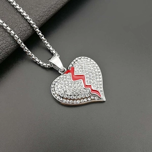 Pendentif cœur brisé argenté avec émail rouge et diamants sur une chaîne gourmette