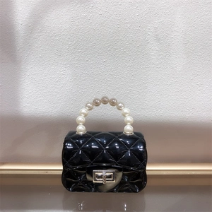 Detail of black mini jelly bag featuring quilted patterns and pearl chain handle design