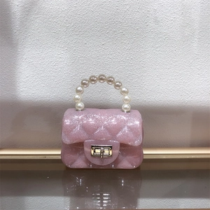 Detailed view of pink glitter jelly bag with quilted pattern and elegant pearl handle
