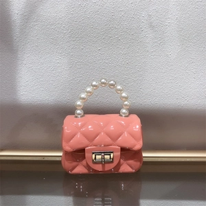 Detailed macro of pink quilted jelly bag with pearl handle and golden twist lock closure