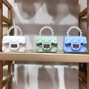 Close-up of PVC jelly mini bags in white, mint, and blue with pearl handles and metal locks
