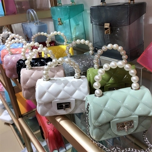 Detail view of mini jelly bags with quilted patterns, pearl handles and metal twist locks