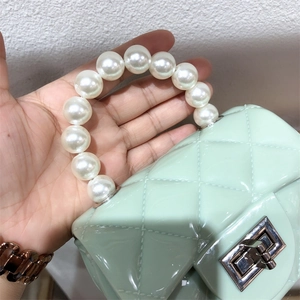 Mini light green PVC jelly bag with quilted pattern, pearl handle, and silver twist lock