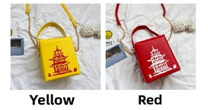Detail of red and yellow crossbody bags with tower print and golden chain straps