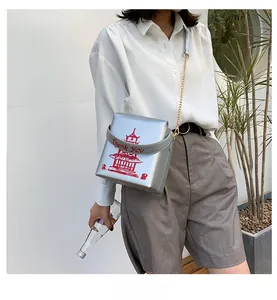 Close-up of silver PU crossbody bag with red Chinese takeout box print and gold chain