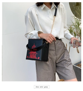 Detail of black leather crossbody bag featuring red tower print and Thank You strap