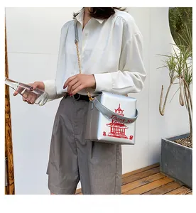 Detail showing the silver square crossbody bag with red pagoda print and chain strap