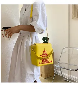 Detail of yellow takeout box crossbody bag with red pagoda print and gold chain strap