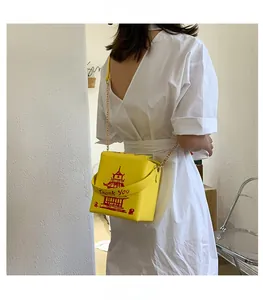 Detail of yellow Chinese takeout box crossbody bag with red pagoda print and gold chain