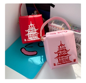 Detail of red and pink takeout box style crossbody bags with pagoda print and chain handle