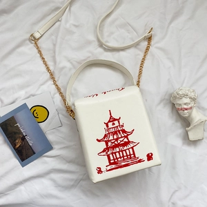 Flat lay of white takeout box crossbody bag with red pagoda print and chain strap