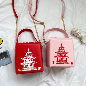Close-up of red and pink PU leather crossbody bags with traditional Chinese tower prints
