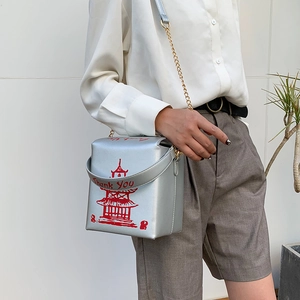 Silver takeout box bag with red tower print and Thank You chain strap shown on model