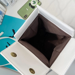 Detail view of the white PU leather crossbody bag interior with magnetic gold snap closure