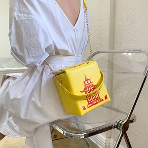 Creative yellow takeout box crossbody bag with pagoda print and gold chain strap on model