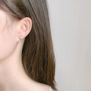 Minimalist 925 silver moonstone stud earrings featuring blue fish tail design on model
