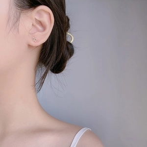 Minimalist S925 sterling silver butterfly stud earrings worn on a model's ear