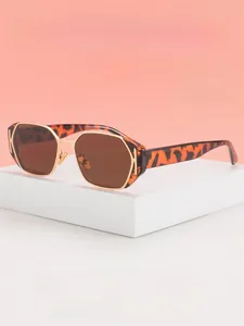 Detail of leopard tortoiseshell sunglasses frame with gold metal accents and dark brown lens