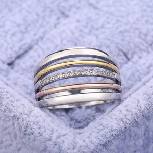Macro shot of S925 stamped three-tone layered rings with zircon on purple velvet