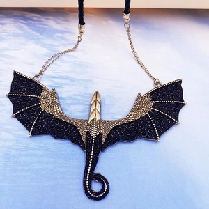 Exaggerated gothic dragon pendant necklace with gold metal wings and black leather cord