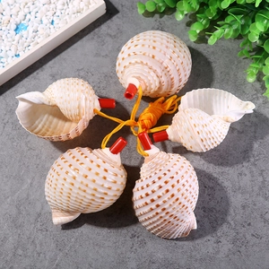 Detailed view of five natural shell whistles with red mouthpieces on yellow strings