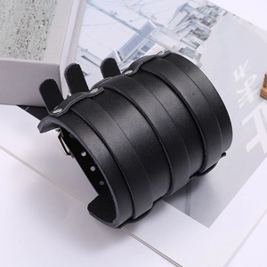 Close-up of black leather punk bracelet featuring multi-layer straps and metal studs