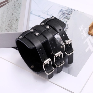 Close-up of black punk leather wide bracelet with metal buckles and silver rivets