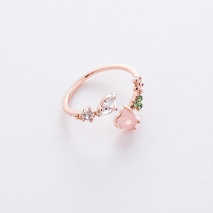 Detail of rose gold open ring featuring pink heart crystal and green floral zircon accents