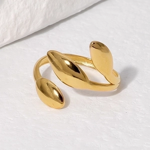 Minimalist golden leaf open ring in stainless steel on white textured background
