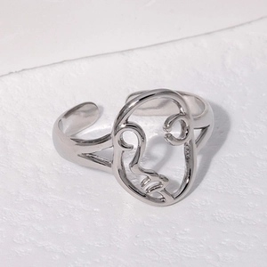 Minimalist silver abstract face adjustable stainless steel ring on a white background