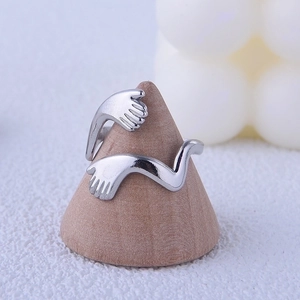 Minimalist silver hug ring in stainless steel shown on a wooden cone display stand