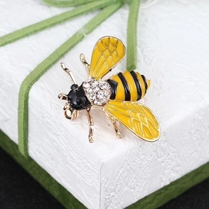 Exquisite bee brooch with yellow enamel and rhinestones on a white textured gift box