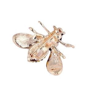 Back view of a gold bee brooch with secure pin clasp and rhinestone details