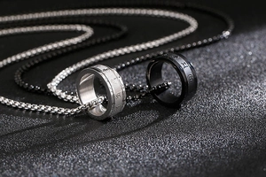 Makroaufnahme von drehbaren Edelstahlringen mit gravierten Symbolen in Silber und Schwarz