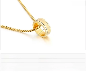 Detail eines drehbaren goldenen Edelstahl-Ringanhängers mit eingravierten Symbolen