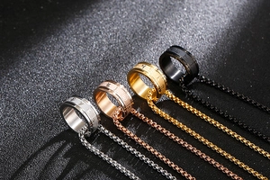 Makroaufnahme von vier drehbaren Mantra-Ringanhängern in Silber Gold und Schwarz Finish
