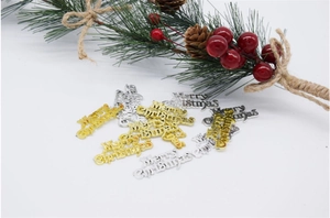Flat lay of gold and silver Merry Christmas sign ornaments with pine branch decor