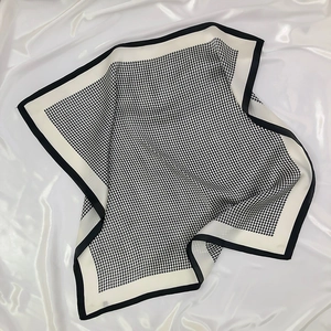 Detailed view of black and white houndstooth silk scarf with elegant rolled edges