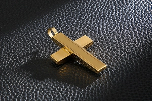 Detail of a gold stainless steel cross pendant with a wire wrap design on black leather