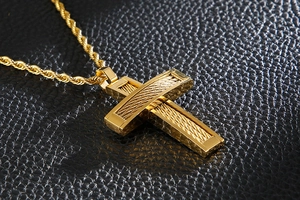 Detailed macro view of a gold cross pendant featuring unique steel wire woven textures