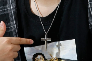 Detail view of double-layered silver cross pendant on a hip-hop twisted rope chain necklace