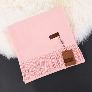 Pink Morandi cashmere scarf with tassels on white fur background for winter warmth