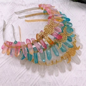 Detailed close-up of pink, blue, and white raw crystals with gold moon pendants on headband