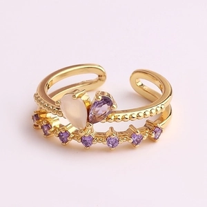 Detail of gold-plated open ring featuring a purple and opal heart-shaped stone