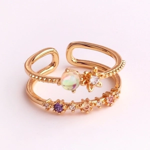 Detail view of double-layer gold open ring with colorful zircon and small flower charm