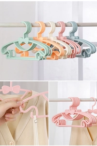 Close-up of adjustable macaron-colored plastic hangers with decorative bow details